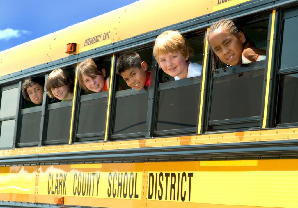 children popping their heads out of the windows of a school bus